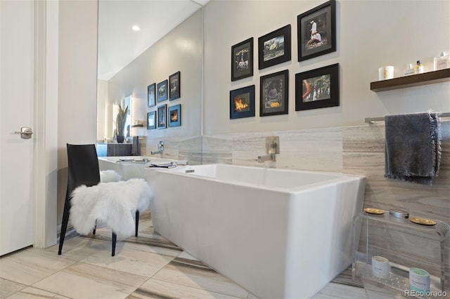 bathroom with tile patterned flooring and a tub to relax in