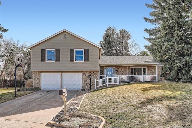 split level home featuring brick siding, concrete driveway, a front yard, covered porch, and a garage