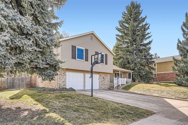 split level home with a front lawn, fence, brick siding, and driveway