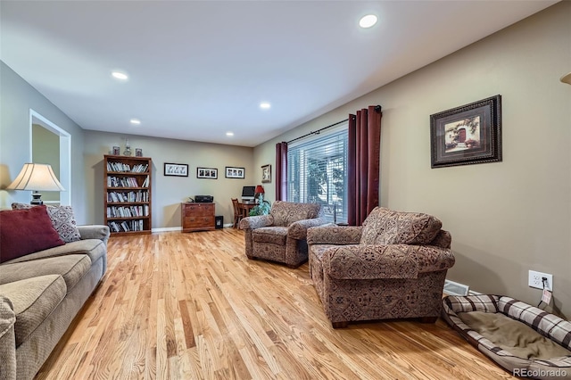 living area featuring light wood-style flooring, recessed lighting, and baseboards