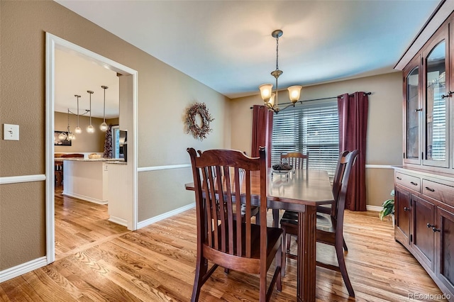 dining space featuring a notable chandelier, light wood-style flooring, and a healthy amount of sunlight