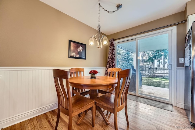 dining room featuring wood finished floors, a chandelier, and wainscoting