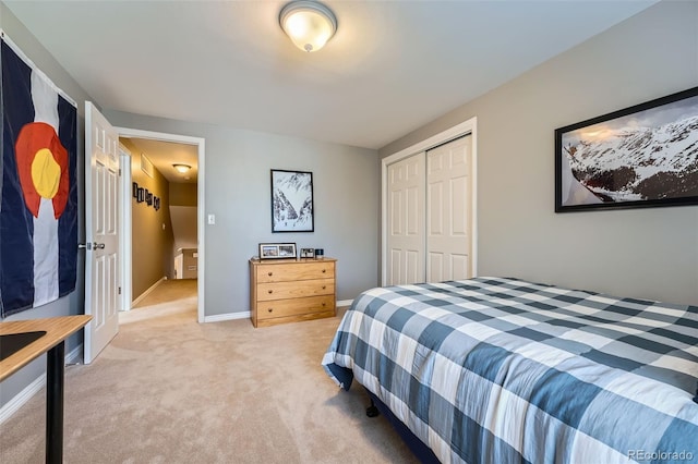 bedroom featuring a closet, light carpet, and baseboards