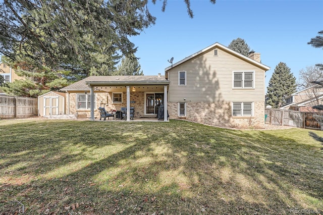 back of property with an outbuilding, a fenced backyard, a storage unit, a patio area, and a lawn