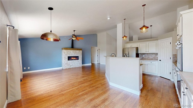 1936 E 144th Dr, Thornton, CO 80602 - kitchen with stainless steel appliances, a ceiling fan, light wood-type flooring, white cabinets, and hanging light fixtures
