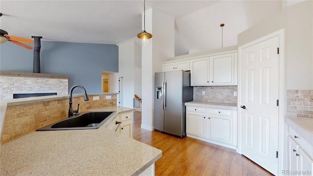 1936 E 144th Dr, Thornton, CO 80602 - kitchen with stainless steel refrigerator with ice dispenser, tasteful backsplash, light wood finished floors, light countertops, and high vaulted ceiling