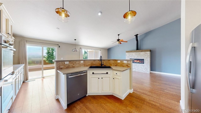 1936 E 144th Dr, Thornton, CO 80602 - kitchen featuring stainless steel appliances, a ceiling fan, open floor plan, decorative backsplash, and light wood-style floors