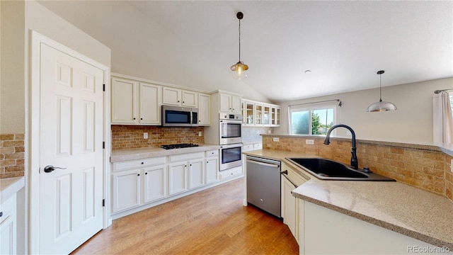 1936 E 144th Dr, Thornton, CO 80602 - kitchen featuring appliances with stainless steel finishes, backsplash, white cabinetry, and lofted ceiling