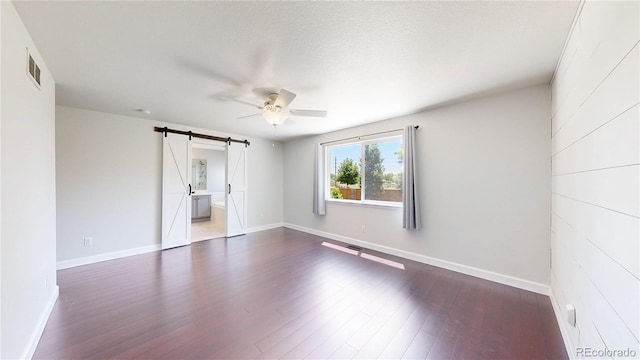 1936 E 144th Dr, Thornton, CO 80602 - spare room with a barn door, a ceiling fan, and dark wood-style floors