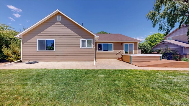 1936 E 144th Dr, Thornton, CO 80602 - back of house with a jacuzzi, a patio, and a lawn