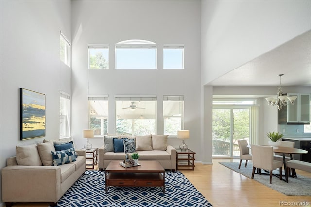 10511 Jaguar Gln, Lone Tree, CO 80124 - living area with a towering ceiling, light wood-type flooring, and a chandelier