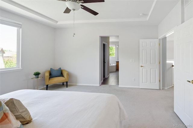 10511 Jaguar Gln, Lone Tree, CO 80124 - bedroom with a tray ceiling, carpet flooring, baseboards, and connected bathroom