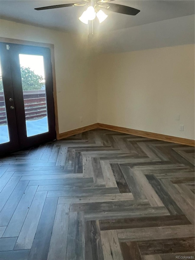 empty room featuring french doors, dark parquet floors, and ceiling fan