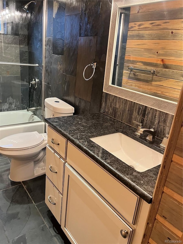 full bathroom with decorative backsplash, vanity, tiled shower / bath combo, and toilet