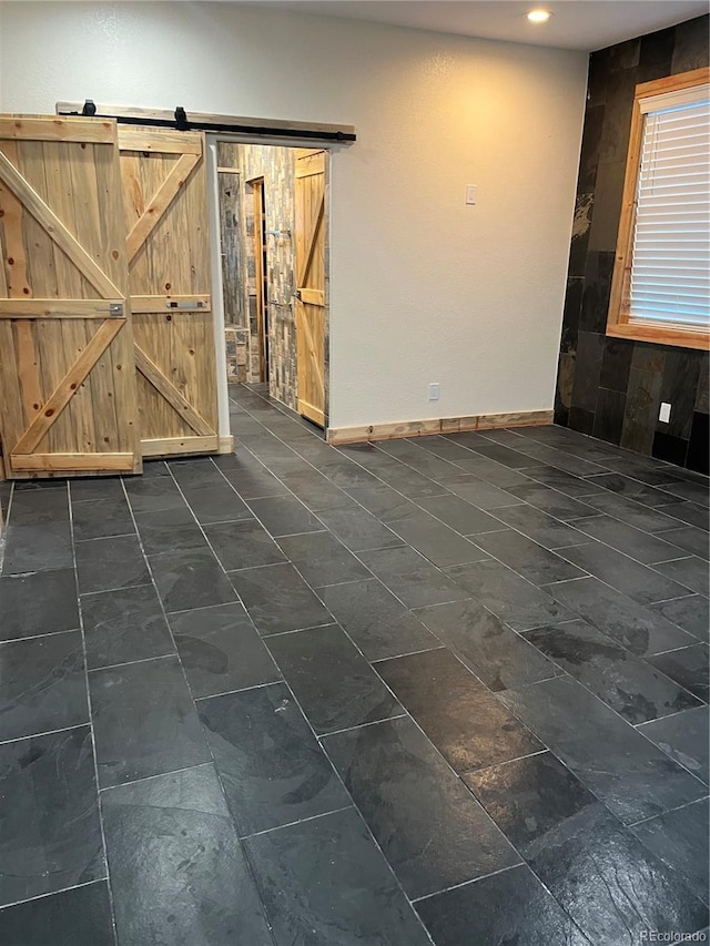 unfurnished room featuring a barn door