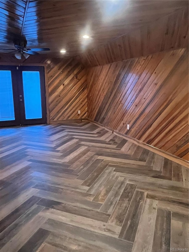 interior space featuring wood walls, dark parquet floors, and ceiling fan