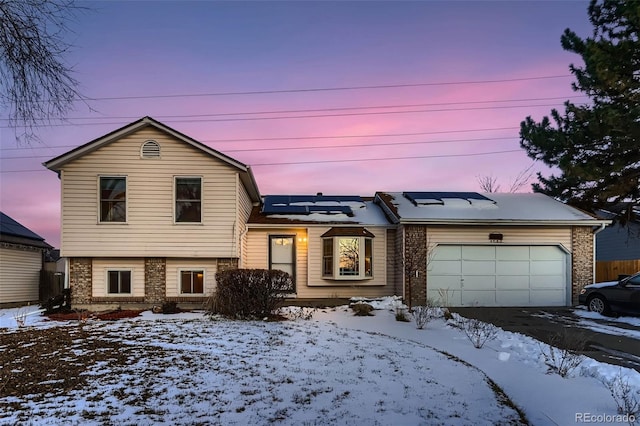 view of front of home with a garage and solar panels