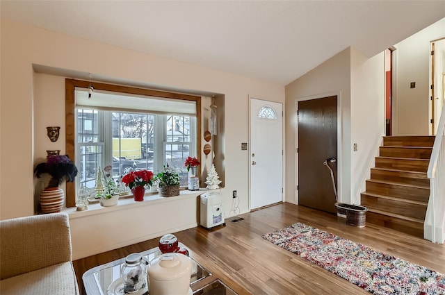 entryway with hardwood / wood-style floors and lofted ceiling