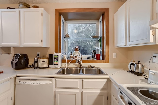 kitchen with white cabinets, sink, white dishwasher, and stove