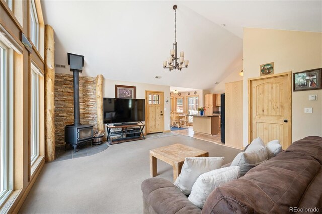21 Crystal Rock Rd, Bailey, CO 80421 - living area with high vaulted ceiling, a chandelier, a wood stove, and light carpet