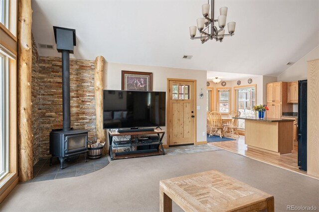 21 Crystal Rock Rd, Bailey, CO 80421 - living area with a wood stove, light carpet, vaulted ceiling, and a chandelier