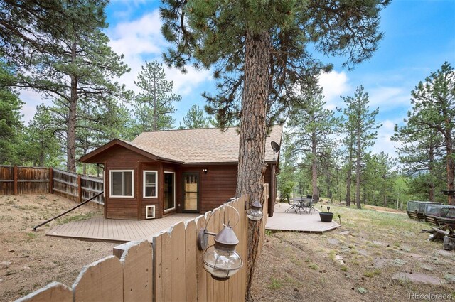 21 Crystal Rock Rd, Bailey, CO 80421 - rear view of house featuring a wooden deck, a shingled roof, and a fenced backyard