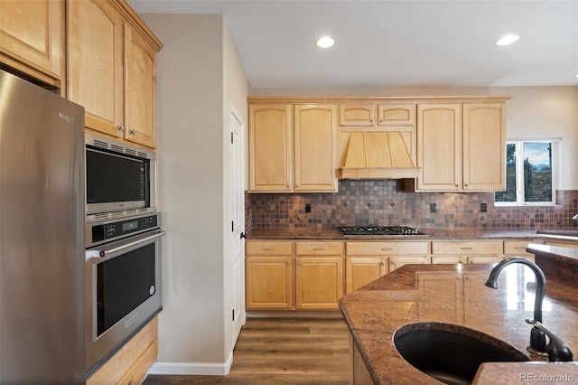 kitchen with light brown cabinetry, appliances with stainless steel finishes, custom exhaust hood, and sink