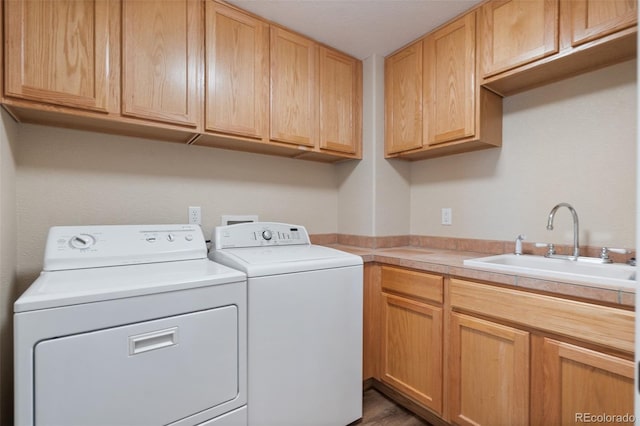 washroom with cabinets, separate washer and dryer, and sink