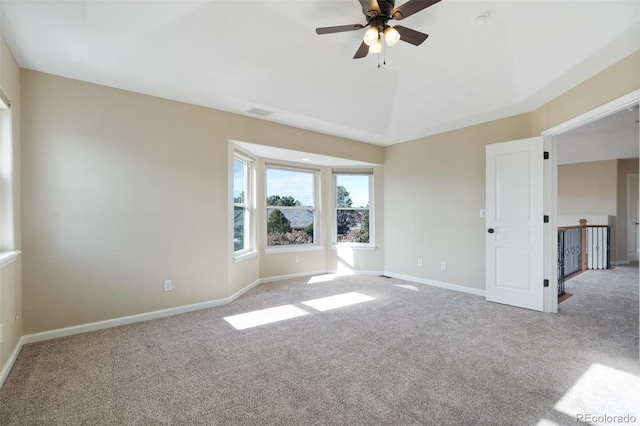 unfurnished room featuring ceiling fan, a tray ceiling, and carpet flooring