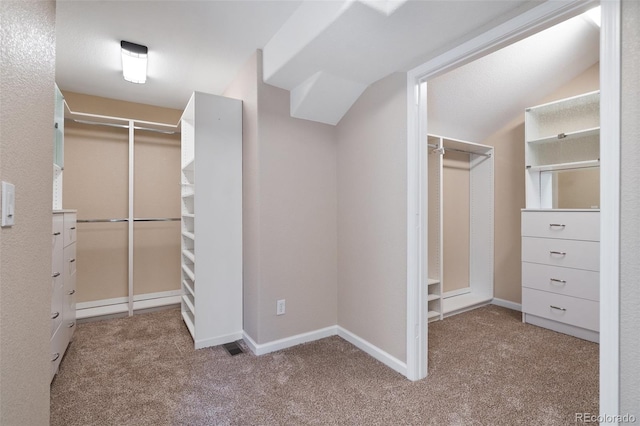 spacious closet featuring vaulted ceiling and light carpet