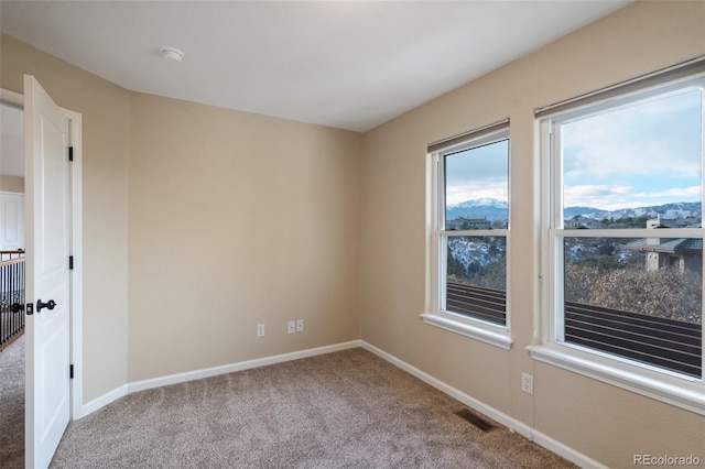 spare room with light carpet and a mountain view