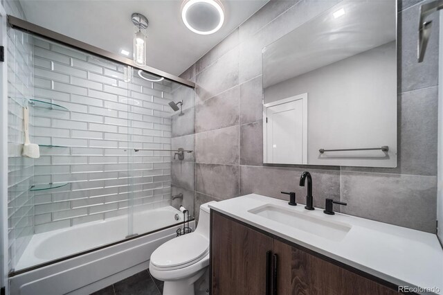 17372 E Prentice Cir, Centennial, CO 80015 - bathroom featuring tile walls, enclosed tub / shower combo, vanity, and toilet