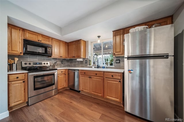17372 E Prentice Cir, Centennial, CO 80015 - kitchen featuring stainless steel appliances, wood finished floors, light countertops, and decorative backsplash