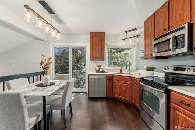 517 Chiswick Cir, Highlands Ranch, CO 80126 - kitchen featuring appliances with stainless steel finishes, dark wood-style floors, light countertops, and hanging light fixtures