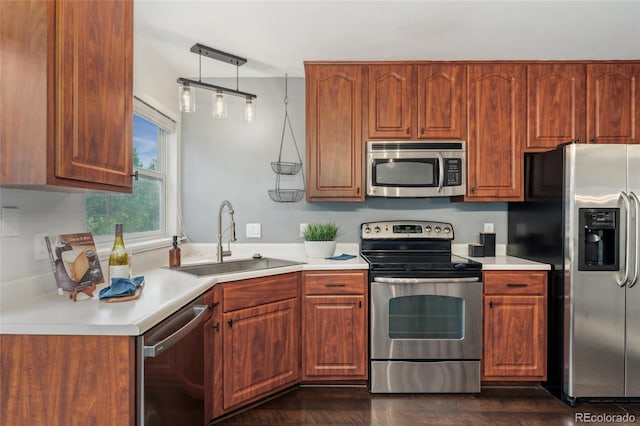 517 Chiswick Cir, Highlands Ranch, CO 80126 - kitchen with stainless steel appliances, light countertops, dark wood-style floors, and hanging light fixtures