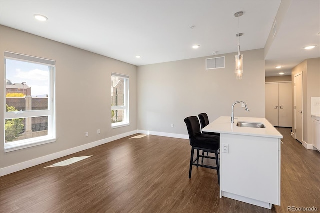 2374 S University Blvd Unit 202, Denver, CO 80210 - kitchen featuring a sink, dark wood-style flooring, baseboards, a breakfast bar area, and pendant lighting