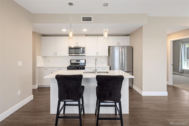 2374 S University Blvd Unit 202, Denver, CO 80210 - kitchen featuring appliances with stainless steel finishes, a sink, baseboards, a center island with sink, and recessed lighting