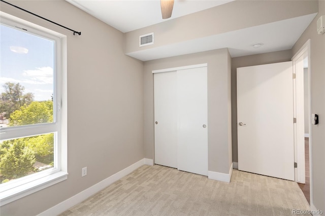 2374 S University Blvd Unit 202, Denver, CO 80210 - unfurnished bedroom featuring a closet, multiple windows, baseboards, and light carpet