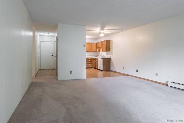 unfurnished living room featuring ceiling fan, a textured ceiling, a baseboard heating unit, and light carpet