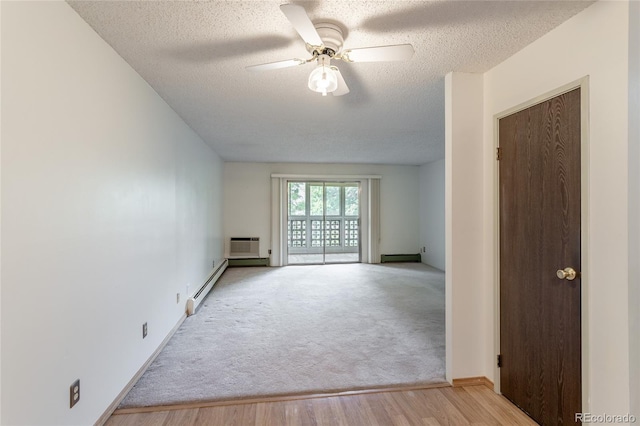 spare room with baseboard heating, a textured ceiling, and a wall unit AC