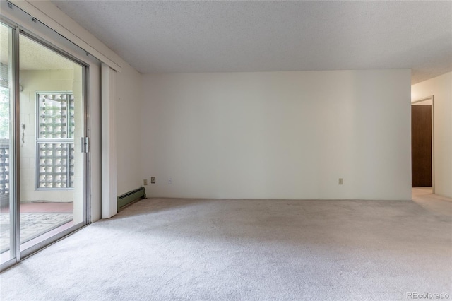 spare room featuring light colored carpet, a textured ceiling, and baseboard heating