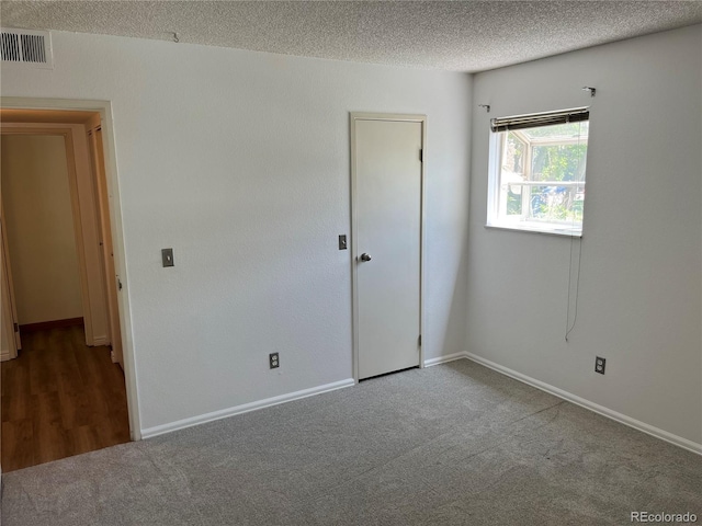 8555 Fairmount Dr Unit A108, Denver, CO 80247 - unfurnished bedroom featuring carpet, a textured ceiling, and baseboards