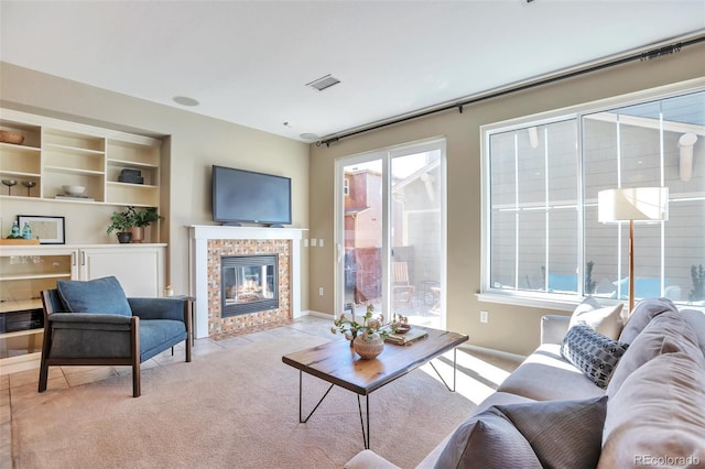 living room with light colored carpet, a fireplace, and a wealth of natural light