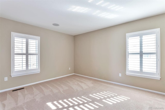 spare room featuring light colored carpet