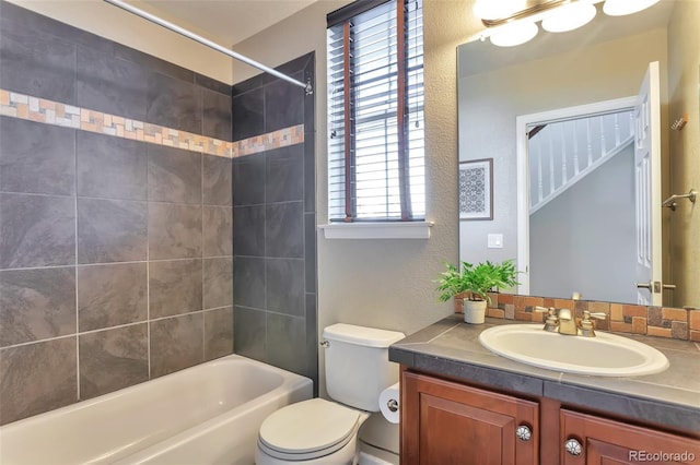 full bathroom with tiled shower / bath combo, vanity, and toilet