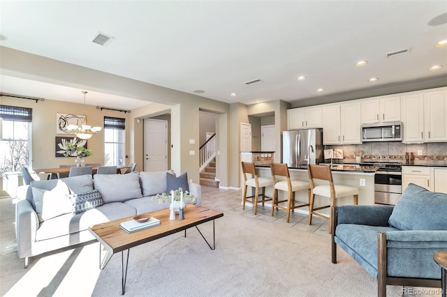 carpeted living room featuring a chandelier