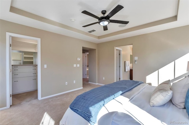 carpeted bedroom featuring a closet, a walk in closet, ceiling fan, and a tray ceiling