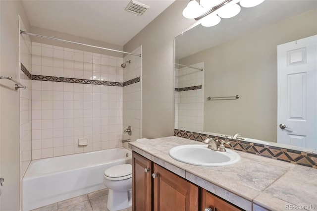 full bathroom featuring tiled shower / bath, vanity, toilet, and tile patterned flooring