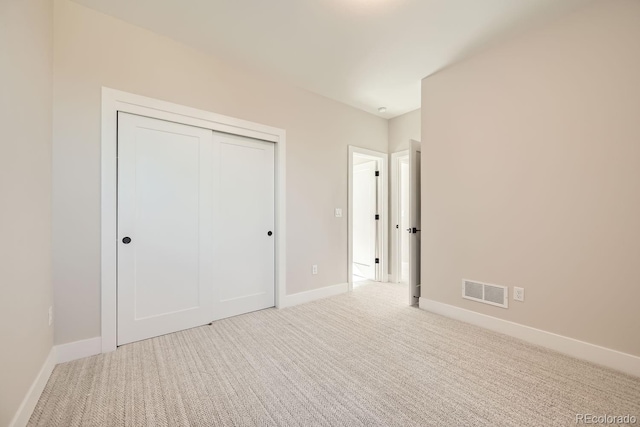 unfurnished bedroom featuring carpet and a closet