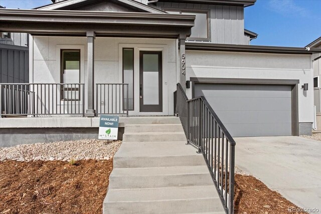 5604 Grandville Ave, Longmont, CO 80503 - view of front of property featuring an attached garage, driveway, stucco siding, and covered porch